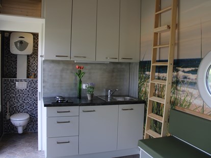 Luxuscamping - Rieste - Küchenbereich mit geöffneter WC Tür
Tiny Ey - Tiny Ferien- und Ausstellungspark