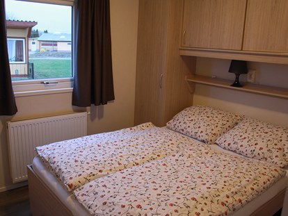 Luxuscamping - Umgebungsschwerpunkt: Stadt - Schlafzimmer mit Doppelbett im Mobilheim "Ocala" - Ostseecamping Ferienpark Zierow