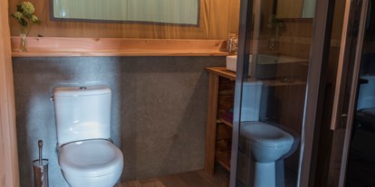 Luxuscamping - Umgebungsschwerpunkt: See - Die Badezimmer der Safarizelte sind geräumig und mit Dusche, Waschbecken und WC ausgestattet.  - Campingpark Heidewald
