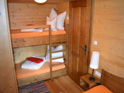 Luxuscamping - Spielplatz - Österreich - Ferienhütte "Schober": Schlafzimmer mit Doppelbett und einem Stockbett - CAMP MondSeeLand