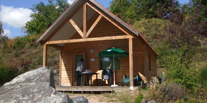 Luxuscamping - Gartenmöbel - Haut-Savoie - Chalet Indigo Aussenansicht  - Camping Huttopia Divonne Chalet Indigo auf Camping Huttopia Divonne
