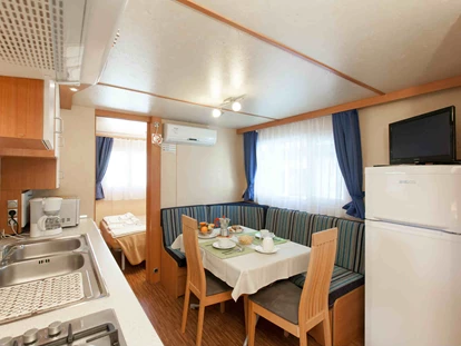 Luxuscamping - Kochmöglichkeit - Italien - Wohnzimmer und Küchenzeile - Camping Ca' Pasquali Village Mobilheim Torcello Plus Gold auf Camping Ca' Pasquali Village