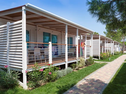 Luxuscamping - Klimaanlage - Außenansicht des Mobilheims mit Terrasse - Camping Vela Blu Mobilheim Laguna Platinum auf Camping Vela Blu