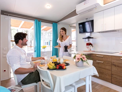Luxuscamping - Art der Unterkunft: Mobilheim - Wohnzimmer und Küche - Camping Vela Blu Mobilheim Laguna Platinum auf Camping Vela Blu