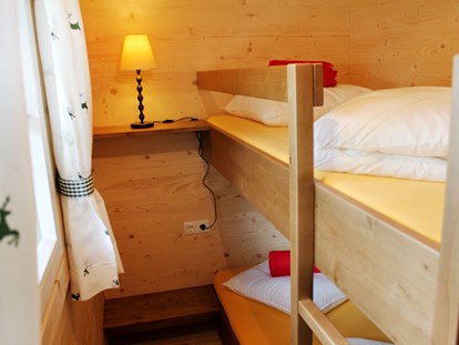 Luxury camping - Kochmöglichkeit - Ferienhütte "Drachenwand": Kinderzimmer mit einem Stockbett - CAMP MondSeeLand Ferienhütten am CAMP MondSeeLand