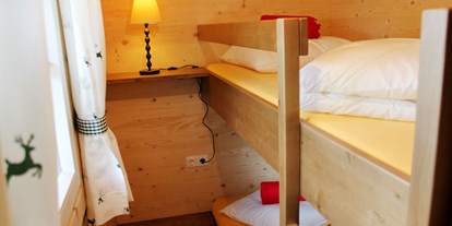 Luxuscamping - Ferienhütte "Drachenwand": Kinderzimmer mit einem Stockbett - CAMP MondSeeLand Ferienhütten am CAMP MondSeeLand