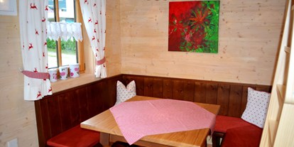 Luxuscamping - Kochmöglichkeit - Ferienhütte "Schober": gemütliche Sitzecke - CAMP MondSeeLand Ferienhütten am CAMP MondSeeLand