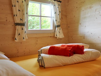Luxuscamping - Art der Unterkunft: Bungalow - Ferienhütte "Schafberg: Schlafzimmer mit Doppelbett - CAMP MondSeeLand Ferienhütten am CAMP MondSeeLand