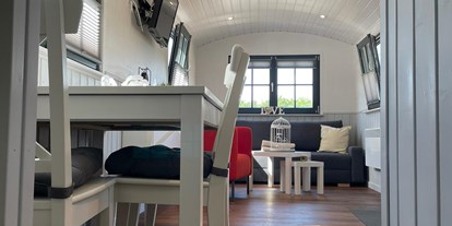 Luxuscamping - Terrasse - Gemütlicher Schäferwagen mit Doppelbett, Küchenzeile, Essbereich, Couch und eigener Toilette. - Campingpark Heidewald Campingpark Heidewald
