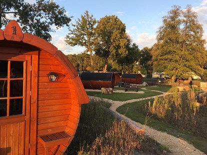 Luxuscamping - Kühlschrank - Schlaffässer mit schöner Anlage und alter Baumbestand runden das Dorfambiente ab. - Campingpark Heidewald Campingpark Heidewald