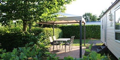 Luxuscamping - Terrasse - Auf der geschützen Aussenterassen lässt es sich gut tafeln ...unsere Mobilheime Komfort. - Campingpark Heidewald Campingpark Heidewald