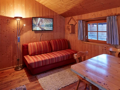 Luxuscamping - Österreich - ausziehbare Couch, gemütlicher Ess- Sitzbereich - Camping Dreiländereck in Tirol Kleine Blockhütte Camping Dreiländereck Tirol