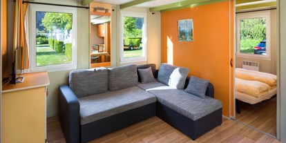Luxuscamping - Gartenmöbel - Schweiz - Wohnzimmer im ein Residence Chalet - Camping de la Sarvaz Klassische Mietchalets am Camping de la Sarvaz