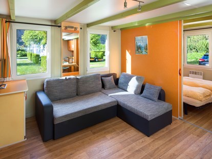 Luxuscamping - Gartenmöbel - Wallis - Wohnzimmer im ein Residence Chalet - Camping de la Sarvaz Klassische Mietchalets am Camping de la Sarvaz