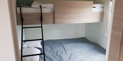 Luxuscamping - Schweiz - Die Mietunterkünfte sind ausgestattet mit Schlafzimmer (1 Doppelbett: 160 x 200cm), 1 Schlafzimmer mit einem Doppelbett (160 cm x 200 cm und einem Kajütenbett (80 x 200cm, max. 60 Kg) Dusche/WC, Wohnküche mit SAT-TV und gedeckter Veranda mit Tisch und Stühlen. Pfannen, Besteck, Microwelle, Kapselmaschine (Tassimo) Geschirr und Gläser, Bettdecken und Kopfkissen sind ebenfalls vorhanden. - Camping Santa Monica Bungalows Typ Marisol am Camping Santa Monica