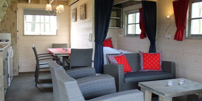 Luxuscamping - WC - Twente - Wohnraum mit Küche und Schlafzimmer mit Doppelbett - Camping De Kleine Wolf Ferienhütte Hooiberg auf Camping De Kleine Wolf