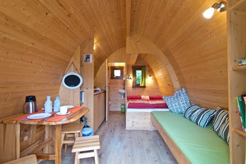 Glampingunterkunft: Sitzecke, Doppelbett und Couch im Pod © Campingpark Kerstgenshof - Pods auf dem Campingpark Kerstgenshof