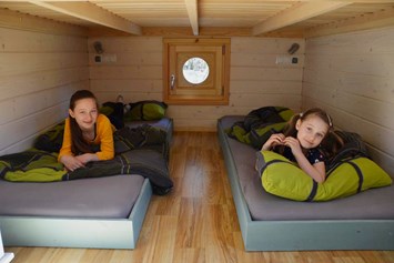 Glampingunterkunft: unterer Schlafbereich - Wurlwagen mit Seeblick - Naturcampingpark Rehberge