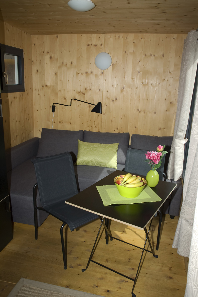 Luxuscamping - Kaffeemaschine - Baden-Württemberg - Innenansicht der Minilodges. Die Sitzgruppe kann in ein bequemes Doppelbett umfunktioniert werden. - Camping Park Gohren Minilodges Camping Park Gohren