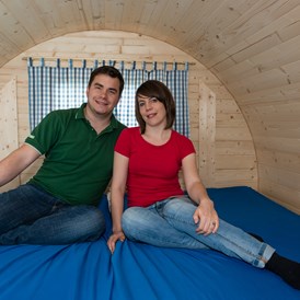 Glampingunterkunft: Das Bett hat 2 x 2 m Liegefläche. Bitte Schlafsack und Kissen mitbringen.
Zusätzlich kann man die beiden Sitzbänke zu zwei Einzelbetten verbreitern, so dass insgesamt 4 Schlafplätze entstehen. - Schlaf-Fass bei Lech Camping
