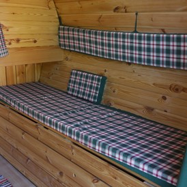 Glampingunterkunft: Die Bank lässt sich verbreitern, so dass ein Einzelbett entsteht auf dem auch ein Erwachsener liegen kann (2,10 x 0,70 cm). - Schlaf-Fass bei Lech Camping