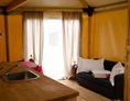 Glampingunterkunft: Glamping-Zelte: Wohnzimmer mit Tisch, Stühlen, Spülbecken, Kühlschrank (ohne Küche) und Schlafsofa - Glampingzelte auf Camping Rialto