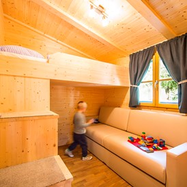 Glampingunterkunft: Das Kinderzimmer ist mit einem Hochbett und einer ausziehbaren Couch (Matratze) sowie Kleiderschrank ausgestattet.  - Bungalow Typ A auf Camping Steiner