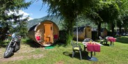 Luxuscamping - Trentino - Tisch mit 2 Stühlen im Aussenbereich, Auto/Motorradparkplatz direkt am Schlaffass. - Schlaffass auf Camping Steiner