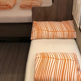 Glampingunterkunft: Umbau Sitzgruppe zum Einzelbett - Deluxe Caravan mit Doppelbett / Dusche