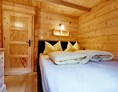 Glampingunterkunft: Schlafzimmer mit Doppelbett - Blockhütte Bergzauber Camping Dreiländereck Tirol