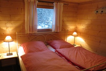 Glampingunterkunft: Landhaus - Schlafzimmer mit Doppelbett - Blockhäuser auf Camping Langenwald