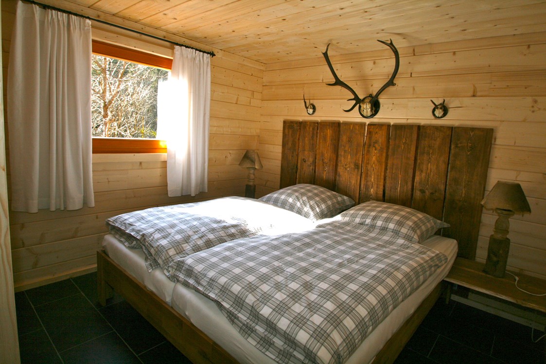 Glampingunterkunft: Jagdhütte - Schlafzimmer mit Doppelbett - Blockhäuser auf Camping Langenwald
