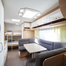 Glampingunterkunft: Innenansicht Etagenbetten und Sitzecke, diese kann zu einem weiteren Doppelbett umgebaut werden - Luxuswohnwagen Premium in Kirchzarten / Schwarzwald