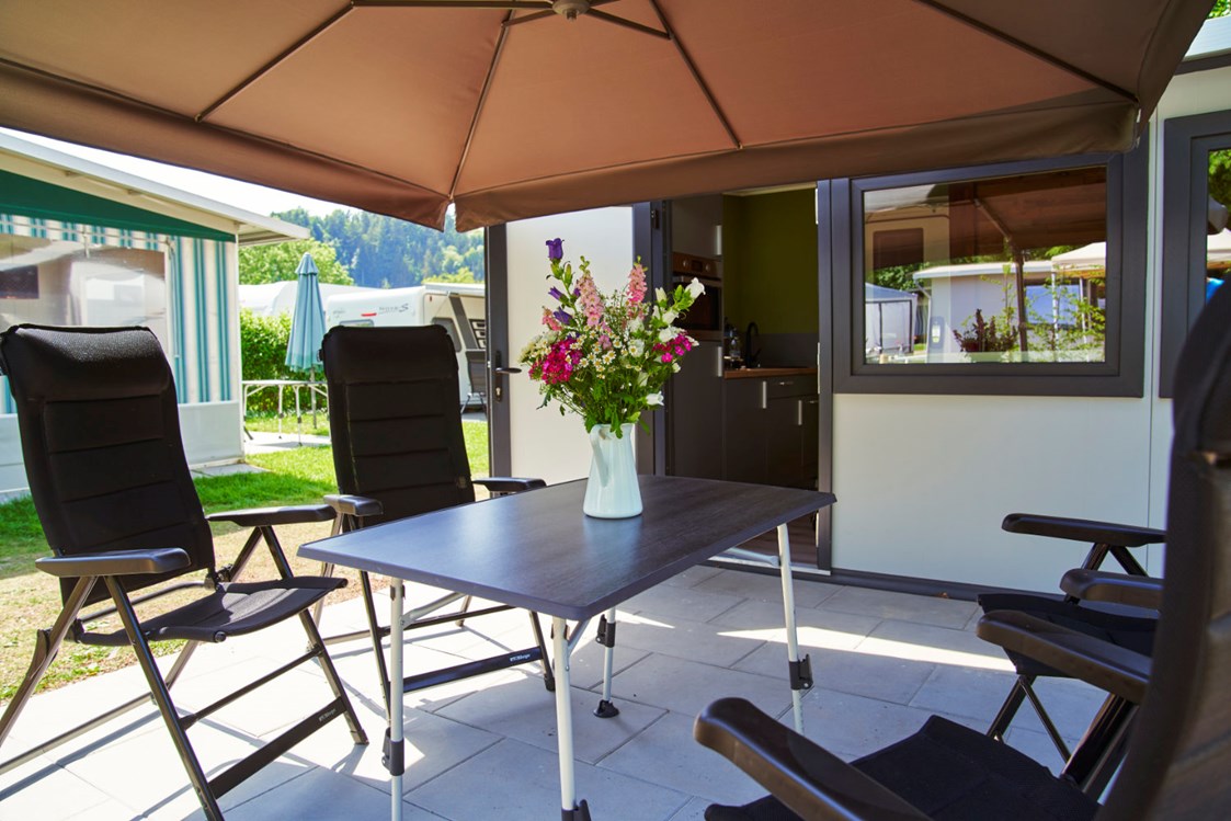 Glampingunterkunft: geräumige, sonnige Terrasse mit Gartenmöbeln und Sonnenschirm - Luxuswohnwagen Premium in Kirchzarten / Schwarzwald