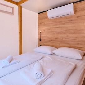 Glampingunterkunft: Schlafzimmer mit Doppelbett - Glamping Zelt Typ Family Premium auf Camping Čikat