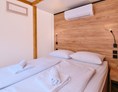 Glampingunterkunft: Schlafzimmer mit Doppelbett - Glamping Zelt Typ Family Premium auf Camping Čikat