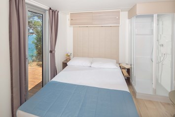 Glampingunterkunft: Schlafzimmer mit Doppelbett - Mobilheim Premium Vista Mare auf Lanterna Premium Camping Resort