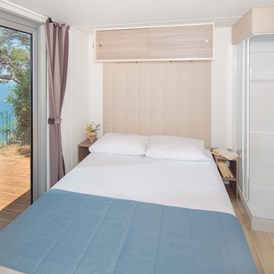 Glampingunterkunft: Schlafzimmer mit Doppelbett - Mobilheim Premium Vista Mare auf Lanterna Premium Camping Resort