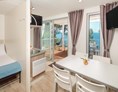 Glampingunterkunft:  Wohnzimmer mit Satelliten-TV - Mobilheim Premium Vista Mare auf Lanterna Premium Camping Resort