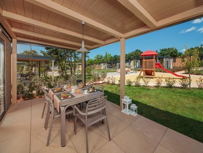 Luxuscamping - Spacious and covered terrace with barbeque - Mobilheim Mediterannean Garden Premium auf Lanterna Premium Camping Resort