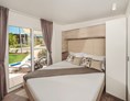 Glampingunterkunft: Schlafzimmer mit Doppelbett - Mobilheim Mediterannean Garden Premium auf Lanterna Premium Camping Resort