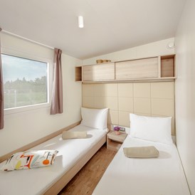 Glampingunterkunft: Kinderschlafzimmer mit 2 Einzelbetten - Mobilheim Mediterannean Garden Premium auf Lanterna Premium Camping Resort