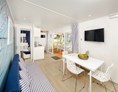 Glampingunterkunft: Wohnraum mit Schlafsofa und LCD-SAT-TV - Mobilheim Marine Premium Family auf Lanterna Premium Camping Resort