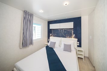 Glampingunterkunft: Schlafzimmer mit Doppelbett - Mobilheim Marine Premium Family auf Lanterna Premium Camping Resort