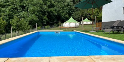 Luxuscamping - Großzügiger Pool, im Hintergrund die Lotus Belle-Zelte - Glamping Vila Trilogy