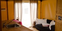 Luxuscamping - Venedig - Glamping-Zelte: Wohnzimmer mit Tisch, Stühlen, Spülbecken, Kühlschrank (ohne Küche) und Schlafsofa - Camping Rialto