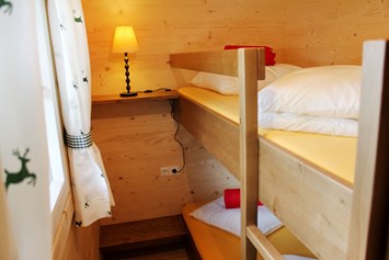 Glamping: Ferienhütte "Drachenwand": Kinderzimmer mit einem Stockbett - CAMP MondSeeLand