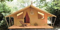 Luxuscamping - Zelt Toile & Bois - Aussenansicht - Zelt Toile & Bois mit Badezimmer und Holzofen auf Camping Huttopia Rambouillet
