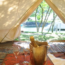 Glampingunterkunft: Sicht auf den Zürichsee - Der Champagner ist bei einer Übernachtung im möblierten Zelt dabei. - Safari-Zelt auf Camping Zürich