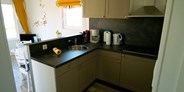 Luxuscamping - Art der Unterkunft: Bungalow - Küche mit Kühlschrank, Ceranfeld und allem was für einen Aufenthalt notwendig ist. - Bungalow Möwe am Ostseecamp Seeblick